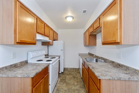 a kitchen with wood cabinets and white appliances and granite counter tops